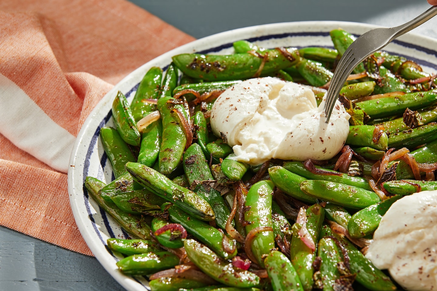Una ensalada crujiente de guisantes se vuelve indulgente cuando se combina con burrata