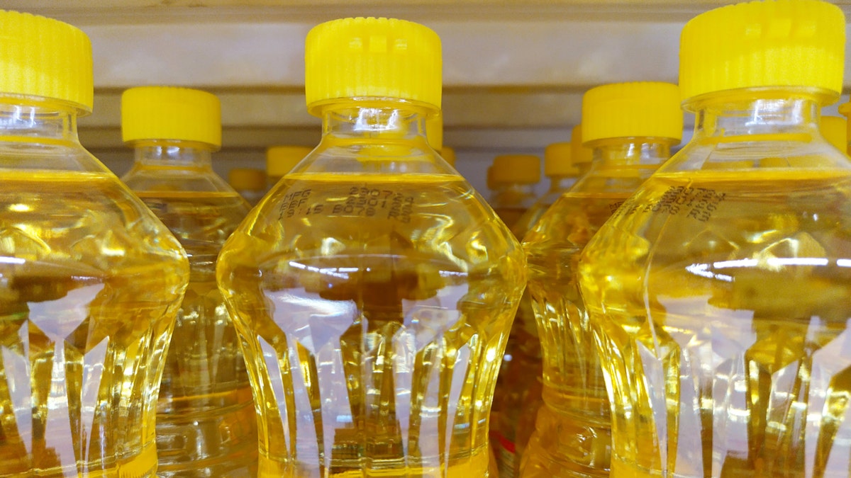 Se muestra una botella de aceite vegetal con una tapa amarilla.