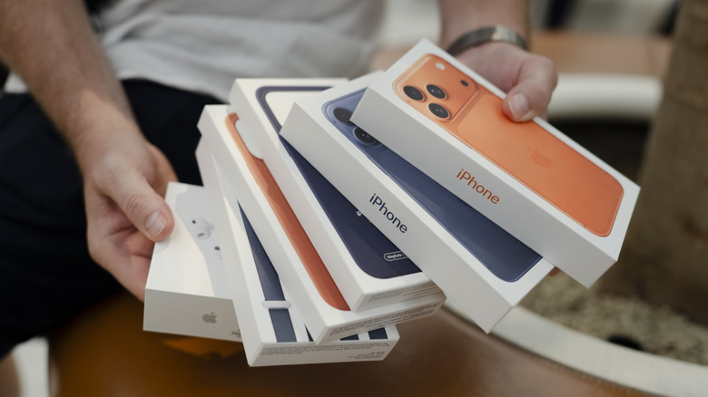 Modelo de iPhone 17 y accesorios en caja de venta al por menor.