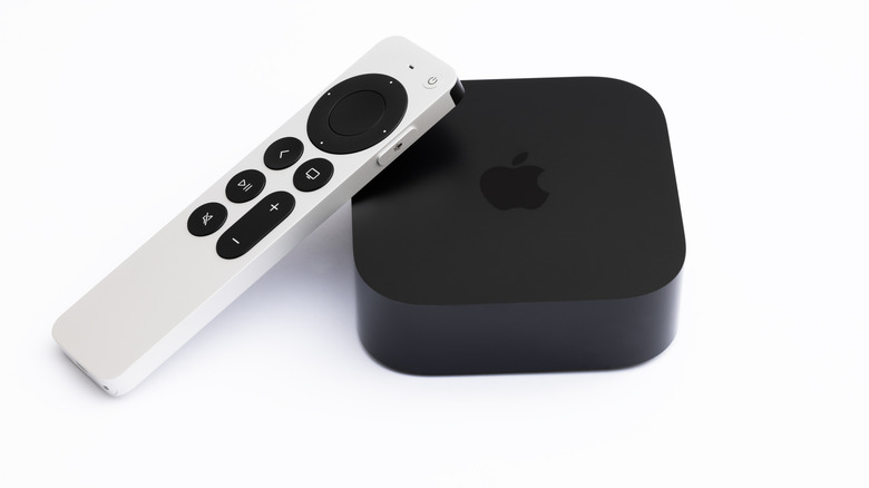 Apoyándose en el Apple TV 4K 2022 con un mando blanco.
