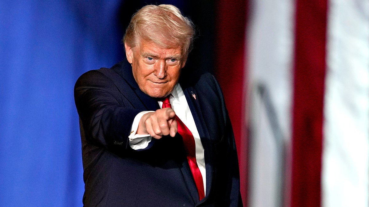 El presidente Donald Trump hace gestos mientras está en el escenario.