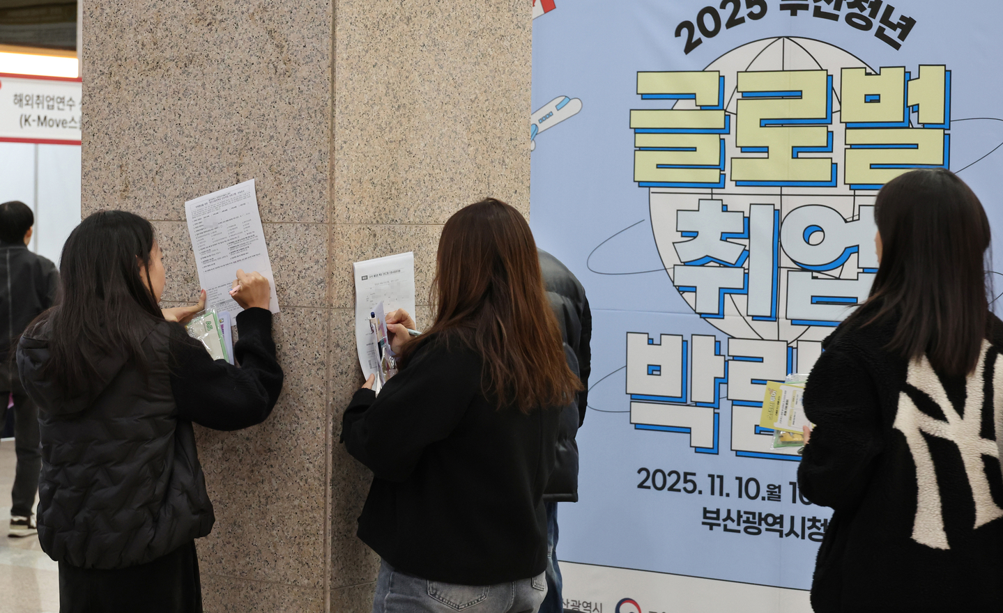 Los solicitantes de empleo completan formularios de solicitud en una feria de empleo en Busan el 10 de noviembre de 2025. (Yonhap) 