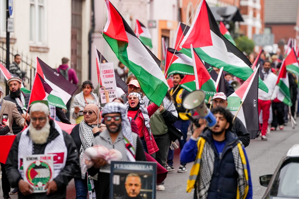 Manifestantes pro palestinos marchan por las calles de Birmingham con banderas y carteles palestinos.