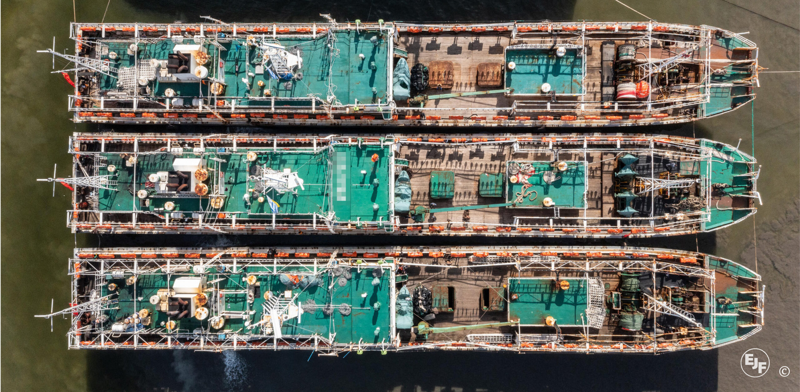 Tres poteros de calamar fotografiados en Montevideo, Uruguay, en 2021. Las entrevistas de EJF vincularon al barco del medio con el corte de aletas de tiburón y la captura de focas durante la pesca. Foto cortesía de EJF.