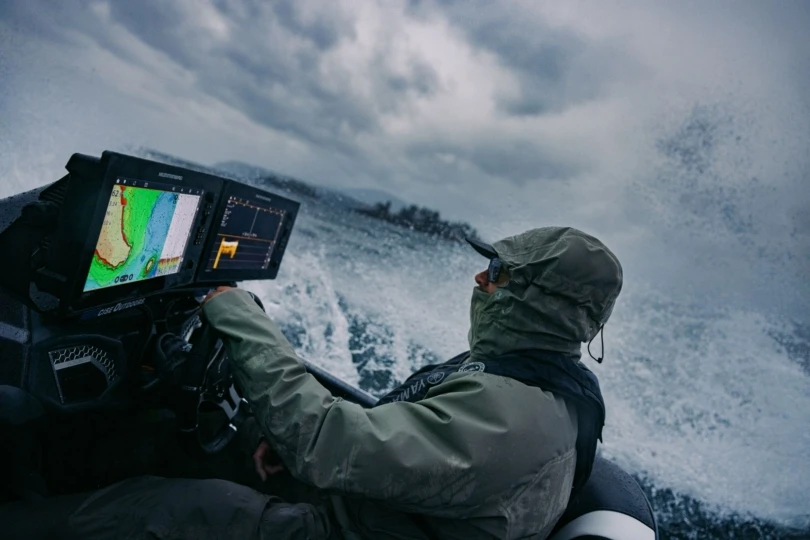 Un pescador dirige un barco en medio de una tormenta.