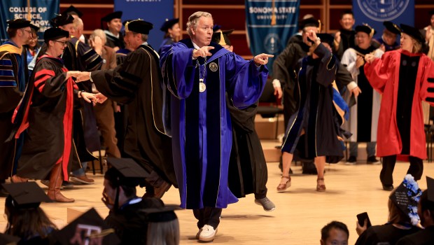 El presidente de la Universidad Estatal de Sonoma, Michael Spagna, baila con el profesorado y el personal durante la graduación de la Facultad de Ciencias, Tecnología y Negocios el sábado 23 de mayo de 2026 en el Greene Music Center en Rohnert Park. (Kent Porter / The Press Democrat)